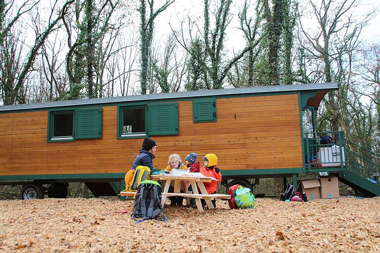 Erzieherin Jana Bördlein spielt mit Kindern vor dem vor wenigen Tagen im Mahlholz bei Gerolzhofen aufgestellten Bauwagen, der den Naturkindergarten beherbergen soll. Wann dieser offiziell starten kann, ist noch offen. Noch fehlt der Betreiberin Jennifer Rasch eine dritte Erzieherin.