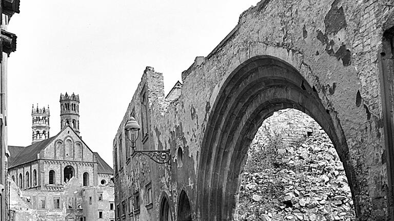 In der Domerschulstraße befindet sich 1950 dieser romanische Torbogen. Der Bogen musste kurz danach wegen der Verbreiterung der Domerschulstraße verschwinden; 1955 wurde er kopiert und diente bis zu deren Schließung als Toreinfahrt zur Theresienklinik. Der Blick geht zum Bruderhof und zum Dom.