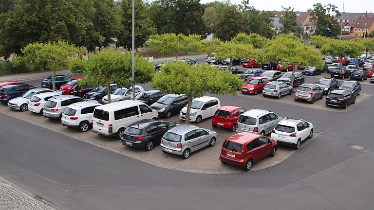 Tagsüber parkende Autos, nachts beliebter Treffpunkt für junge Menschen: der Bleichwasen in der Stadt Kitzingen.