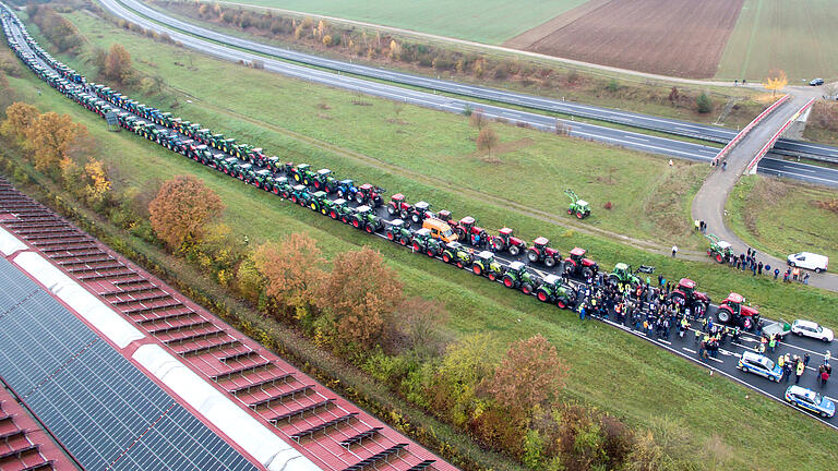 Anand Anders       -  Schier endlos ist die Traktor-Kolonne, die sich am Sonntagmorgen auf der Bundesstraße 19 bei Geldersheim aufgereiht hat. Mit über 300 Fahrzeugen starteten die Landwirte von hier aus zur Großdemo am Dienstag nach Berlin.