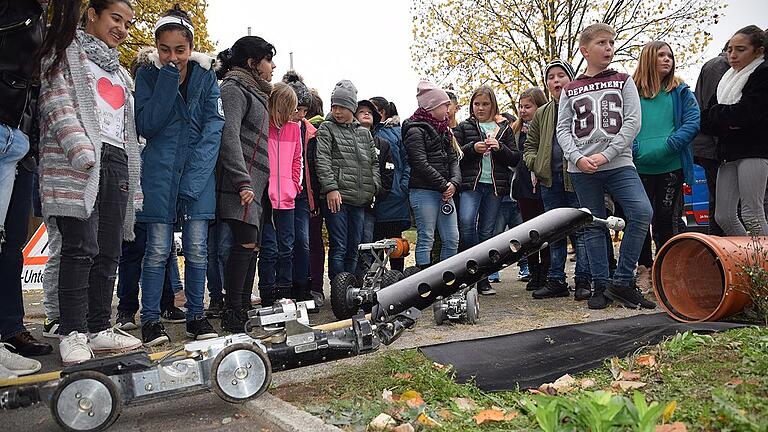 Schüler der Gemündener Mittelschule verfolgen, wie für die Rohruntersuchung ein Roboter in ein Rohr gefahren wird.