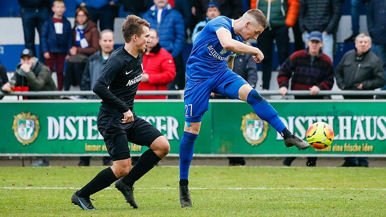 Dennie Michel (rechts) vom Würzburger FV zieht aus kurzer Entfernung vor Andreas Rösch vom TSV Karlburg ab. Es war eine von nur wenigen guten Torchancen der Gastgeber, die zwar mehr Ballbesitz hatten, doch hielten die Karlburger mit großem Einsatz dagegen.