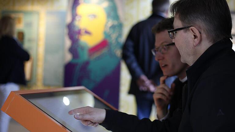 Rückert hat alles im Blick: Zwei Besucher probieren die Multimedia-Station im Poetikum aus, bei der man die Gedichte über die Rückertschen Kinderjahre in Originalhandschrift lesen und erfahren kann, was Rückert geändert hat.