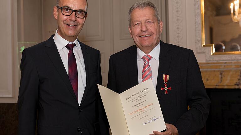 Robert Menschick (rechts) mit Verdienstkreuz und Urkunde.