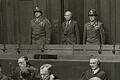 NS-Richter Oswald Rothaug als Angeklagter zwischen zwei amerikanischen Offizieren im Gerichtssaal 600 bei den Nürnberger Prozessen.
