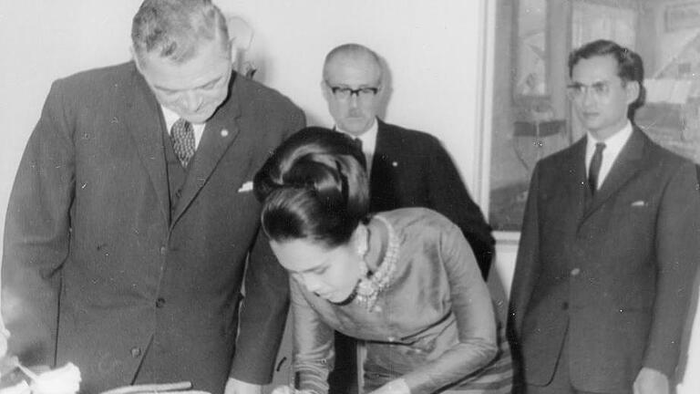 Königin Sirikit schreibt sich in das Goldene Buch der Stadt Bad Kissingen in Gegenwart von (von links) Oberbürgermeister Dr. Weiß, Protokollchef Freiherr von Brand und ihres Gatten König Bhumibol ein. Foto: Archiv/Curt Kleintitschen       -  Königin Sirikit schreibt sich in das Goldene Buch der Stadt Bad Kissingen in Gegenwart von (von links) Oberbürgermeister Dr. Weiß, Protokollchef Freiherr von Brand und ihres Gatten König Bhumibol ein. Foto: Archiv/Curt Kleintitschen