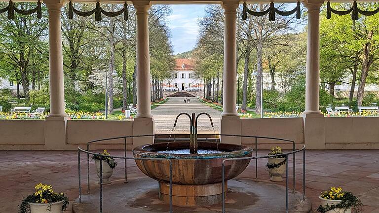 Der Balthasar-Neumann-Heilwasserbrunnen im Jubiläumsjahr 2024 mit Blick auf den Fürstenbau       -  Der Balthasar-Neumann-Heilwasserbrunnen im Jubiläumsjahr 2024 mit Blick auf den Fürstenbau