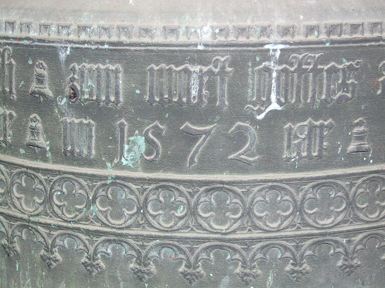 Die Glocke von 1572 in einer Nahaufnahme: Man erkennt die reiche Verzierung und über der Jahreszahl 1572 den Textausschnitt 'zum wort gottes'. Die Glocke von 1572 in einer Nahaufnahme: Man erkennt die reiche Verzierung und über der Jahreszahl 1572 den Textausschnitt 'zum wort gottes'.