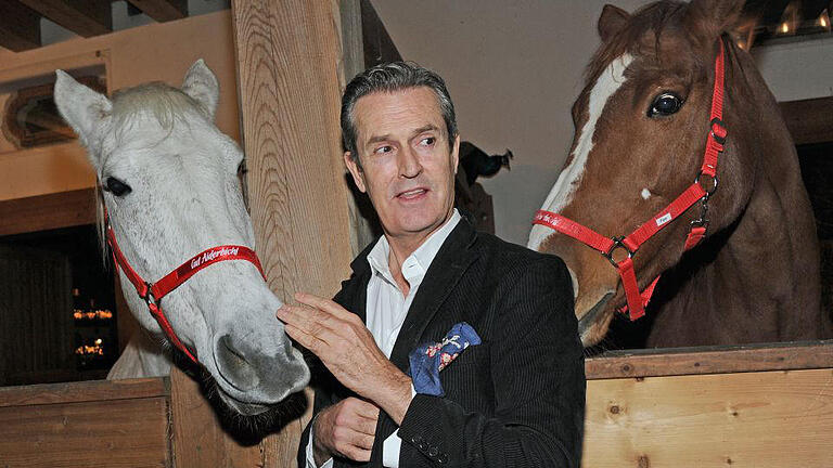 Eröffnung Weihnachtsmarkt 2015 auf Gut Aiderbichl       -  Der britische Schauspieler Rupert Everett posiert am 10.11.2015 mit Pferden bei der traditionellen Weihnachtsausstellung auf Gut Aiderbichl in Henndorf bei Salzburg (Österreich). Am 05.12.2015 um 20.15 Uhr wird die Sendung «Advent auf Aiderbichl» im ORF 2 und 'tierisch,tierisch' am 23.und 30.Dezember 2015 jeweils um 19.50 Uhr ausgestrahlt und über die Weihnachtsausstellung berichtet. Auf dem Gnadenhof werden Tiere aufgenommen, die eine traurige Vorgeschichte haben. Foto: Ursula Düren/dpa +++(c) dpa - Bildfunk+++