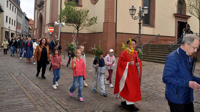 Feierlicher Prozessionszug von der Laurentiuskirche zur Kirche St. Josef. Die neuen Kommunionkinder begleiteten Pfarrer Becker mit  bunt geschmückten Palmbuschen.