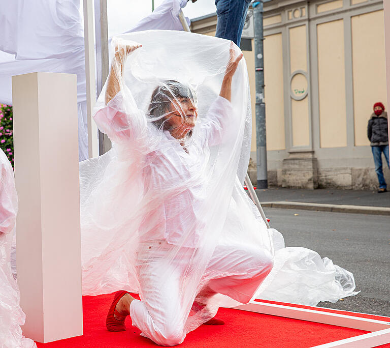 Die Würzburger Tänzerin Lisa Kuttner wühlte sich aus halbtransparenten Planen hervor. Die Würzburger Tänzerin Lisa Kuttner wühlte sich aus halbtransparenten Planen hervor.