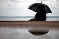 Der Herbst kommt       -  ARCHIV - Eine Frau sitzt am 19.08.2015 bei verregnetem Wetter unter einem Regenschirm am Ammersee in Herrsching (Bayern). Foto: Matthias Balk/dpa (zu dpa 'Der Herbst kommt: die schönen und die tristen Seiten' vom 31.08.2015) +++(c) dpa - Bildfunk+++