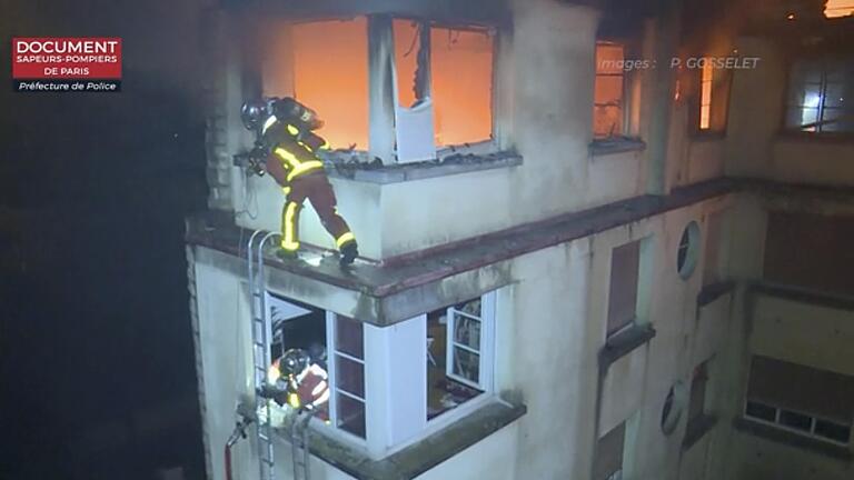 Das Videostandbild zeigt Feuerwehrleute im Einsatz an dem brennenden Mehrfamilienhaus.&nbsp;