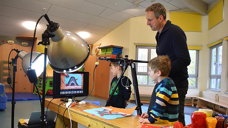 Im Dettelbacher Kindergarten 'Haus für Kinder St. Sebastian' werden die digitalen Medien besonders für ein Vulkanprojekt genutzt. Der Wissenschaftler Valentin Troll, der an einer schwedischen Universität lehrt, unterstützt die Kinder dabei aus der Ferne. Der Mediencoach Frank Findeiß (im Bild) sowie Lasse und Jakob bereiten eine Aktion für das Projekt vor.