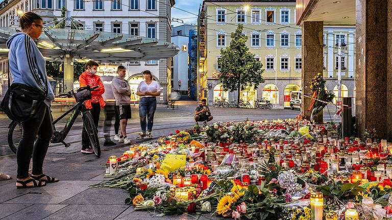 Fünf Tage nach dem Messerangriff am Barbarossaplatz in Würzburg legen dort noch immer Menschen Blumen im Gedenken an die Opfer nieder.