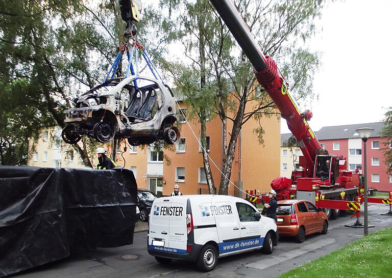 Ein Beispiel aus Dortmund: Ein Kranwagen der dortigen Feuerwehr hebt ein ausgebranntes E-Auto in einen Container, der dann mit Wasser geflutet wird. Die Batterie des Kleinwagens kann noch bis zu 48 Stunden unlöschbar weiterbrennen.&nbsp;