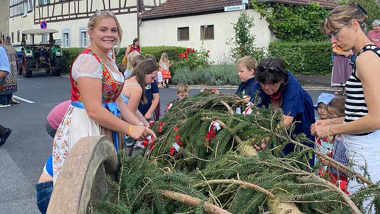 Auch Weinprinzessin Larissa Hegmann schmückte mit Fähnchen den Kirchweihbaum, ehe er in die Höhe am Mainberger Plan gehoben wurde