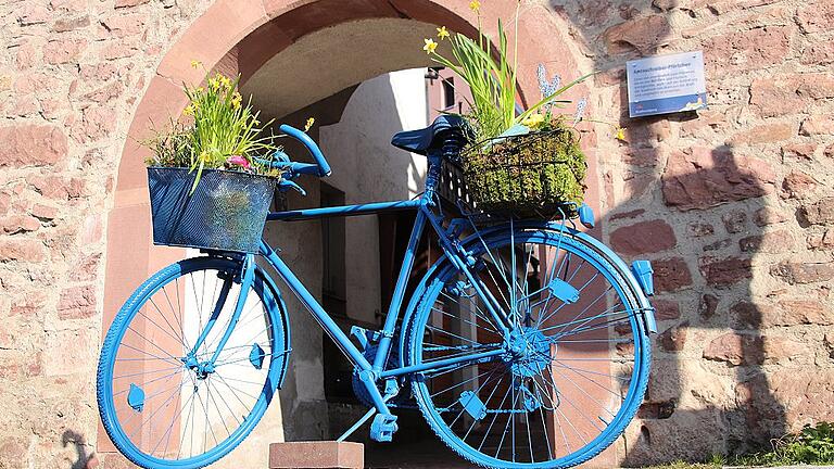 Mit dem Fahrrad mit Blumenkörben weist der Verein Stadtmarketing Gemünden auf den Frühlingsmarkt hin.