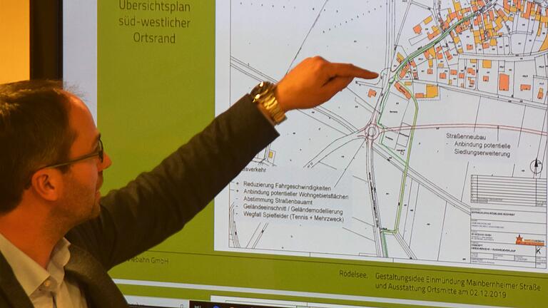 Planer Marcus Viebahn präsentierte dem Gemeinderat Rödelsee Zukunftspläne für den südwestlichen Ortsrand von Rödelsee: Mit Kreisverkehr und Südspange für die Erschließung eines möglichen neuen Baugebiets sowie eine Gestaltungsidee bei der Einmündung der Mainbernheimer Straße in die Umgehungsstraße. Dabei ging der Planer noch von einem Stehenbleiben der Garagenanlage beim Sportheim aus. Der Gemeinderat möchte diese jedoch abreißen. Planer Marcus Viebahn präsentierte dem Gemeinderat Rödelsee Zukunftspläne für den südwestlichen Ortsrand von Rödelsee: Mit Kreisverkehr und Südspange für die Erschließung eines möglichen neuen Baugebiets sowie eine Gestaltungsidee bei der Einmündung der Mainbernheimer Straße in die Umgehungsstraße. Dabei ging der Planer noch von einem Stehenbleiben der Garagenanlage beim Sportheim aus. Der Gemeinderat möchte diese jedoch abreißen.