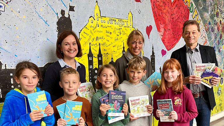 Rektorin Carola Günther, Konrektorin Monika Obermeier-Giehl und Viertklasskinder freuen sich über die großzügige Bücherspende des Rotary-Clubs Würzburg-Stein, überreicht durch Jürgen Geisel. Rektorin Carola Günther, Konrektorin Monika Obermeier-Giehl und Viertklasskinder freuen sich über die großzügige Bücherspende des Rotary-Clubs Würzburg-Stein, überreicht durch Jürgen Geisel.