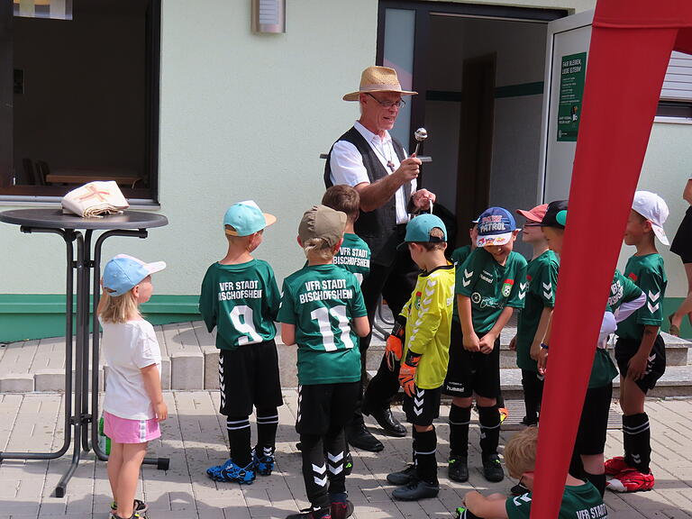 Mit der feierlichen Übergabe wurde der Abschluss der Arbeiten und die Umbenennung in Rudi-Jung-Sportanlage in Bischofsheim gefeiert. Umringt von den Jüngsten des Vereines spendete Stadtpfarrer Manfred Endres den Segen.