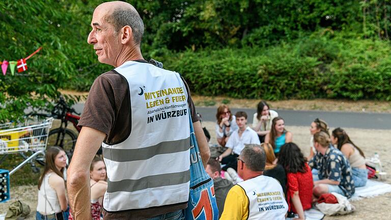 Die Mediatoren Thilo Wolf (vorne) und Stefan Schneider im Gespräch mit Feiernden auf der Sanderauer Mainwiese.