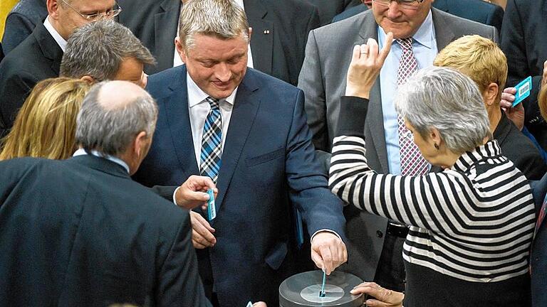 Bundestag       -  Gewissensentscheidung: Bundesgesundheitsminister Hermann Gröhe (Mitte) wirft im Bundestag bei der namentlichen Abstimmung über den Gesetzentwurf zur Sterbehilfe seine Stimmkarte in eine Urne.