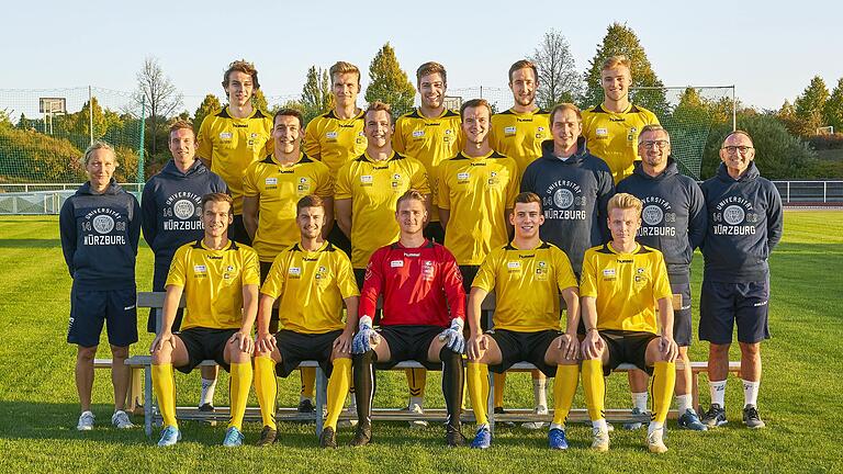 Die Hochschulmannschaft der Uni Würzburg mit (hinten von links) Ferdinand Hansel, Levi Wendel, Erik Schnell-Kretschmer, Adrian Dußler, Yannick Reinhart, (Mitte von links) Physio Eva Wenzlik, Physio Sebastian Fries, Ben Müller, Stefan Wasser, Simon Wengeler, Co-Trainer Tim Lorenz, Delegationsleiter Anton Kramer, Trainer Gerhard Bömmel und (vorne von links) Moritz Lotzen, Schriftführer Michael Dietl, Pascal Krämer, Alexander McBride, Paul Obrusnik. Es fehlen: Pascal Jeni, Max Wolf, Franz Ruppel, Lukas Illig und David Bröer.