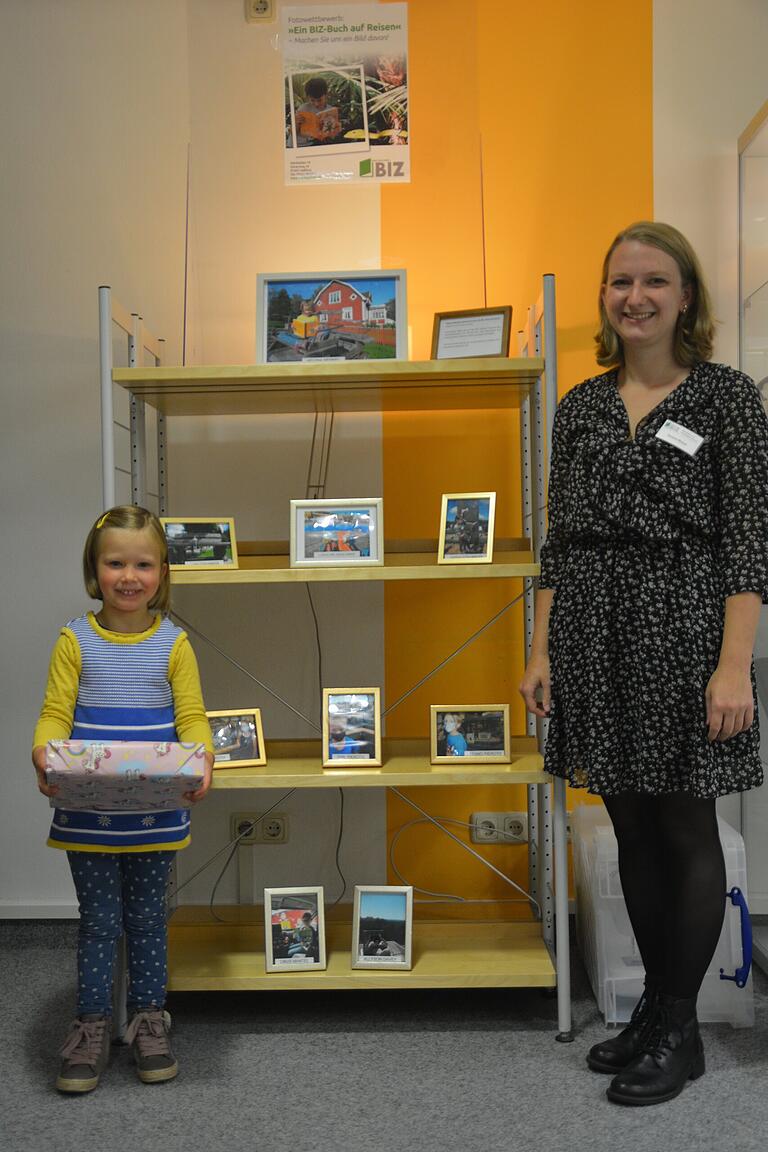 Gewinnerin Helena Memmel und BIZ-Mitarbeiterin Verena Braun bei der Preisverleihung. Sie stehen gemeinsam vor der Ausstellung, bei der die schönsten Zusendungen der Leserinnen und Leser gezeigt werden.