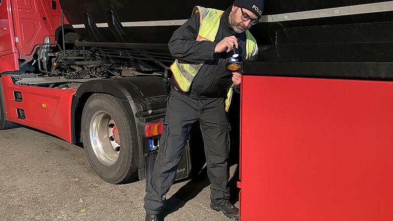 Martin Lang, Kontrollbeamter beim Schwerverkehrstrupp der VPI Schweinfurt-Werneck, kontrolliert die Technik eines Lkw.