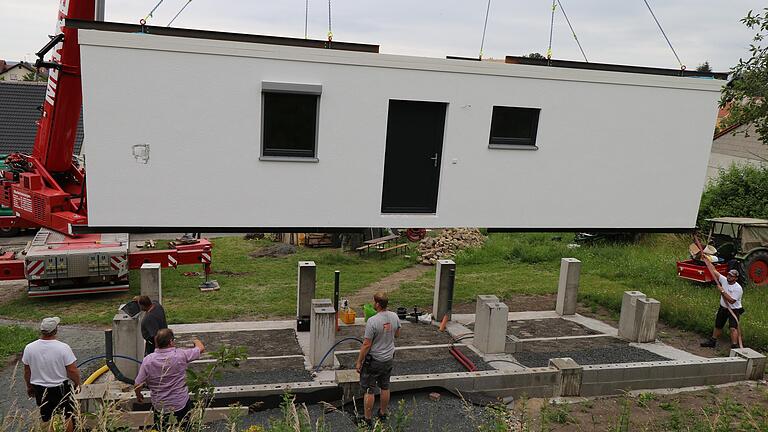 Ein Haus am Drahtseil: Gerade einmal fünf Arbeiter brauchte es, um das Modulhaus von Alexander Derra auf die Fundamente zu stellen.
