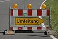 Umleitungen       -  (pp)   Zwei Hinweisschilder mit unterschiedlicher Information stehen für Autofahrer in Eußenheim. Auf dem Schild an der Bushaltestelle am Ortsausgang von Eußenheim Richtung Karlstadt (siehe oben) wird auf eine Sperrung der Staatsstraße 2301 zwischen Eußenheim und Schönarts hingewiesen und als Umleitung die &bdquo;U1&ldquo; über Karlstadt angeboten. Direkt nach der Abzweigung nach dem Ortsende von Eußenheim in Richtung Schönarts wird allerdings darauf hingewiesen (siehe unteres Foto), dass die Straße &bdquo;Frei bis Schönarts Heßlar&ldquo; ist.Richtig ist, dass aufgrund einer Baustelle am Ortseingang von Stetten (Brückbergstraße) der Teilbereich der Staatsstraße nach der Abzweigung nach Heßlar bis Stetten für den Durchgangsverkehr gesperrt ist. Die Straße, die vor dem Ortsschild in Stetten nach links am Feuerwehrgerätehaus und Sportplatz vorbeiführt, ist gleichfalls gesperrt und &bdquo;Nur für Anlieger&ldquo; frei gegeben. Nach Auskunft des Werkleiters der Stadtwerke Karlstadt, Klemens Albert, werden die Baumaßnahmen bis Ende des Jahres dauern. Auch die Umleitung wird so lange bestehen.