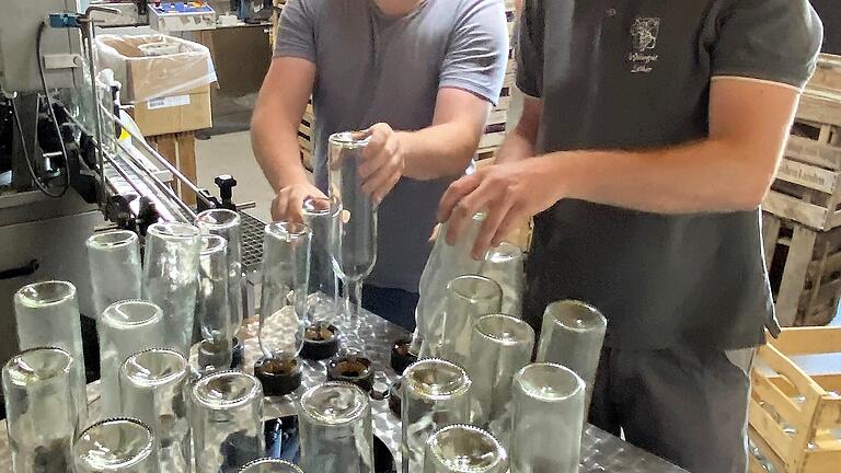 Vor der Befüllung müssen die Flaschen gespült werden. Markus Hümpfer und Winzer Sebastian Lother. Vor der Befüllung müssen die Flaschen gespült werden. Markus Hümpfer und Winzer Sebastian Lother.