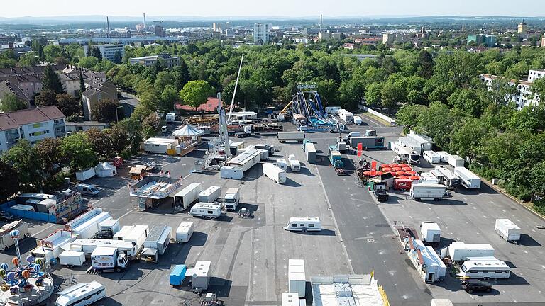 Der Aufbau des Schweinfurter Volksfests ist kurz vor der Eröffnung in vollem Gange. Aus den 36 Gondeln des Riesenrads Jupiter lässt sich das Treiben von oben beobachten.