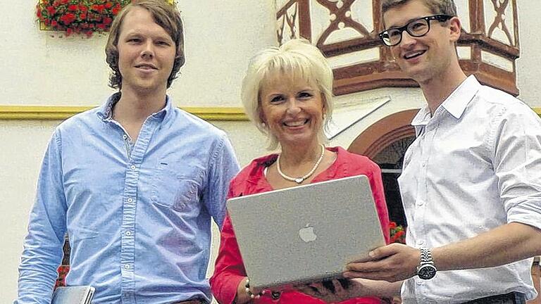 Erfolgreiche Jungunternehmer: Daniel Unger (links) und Axel Scheuering von der Firma Eology mit Landrätin Tamara Bischof und Laptop auf dem Volkacher Marktplatz. Erfolgreiche Jungunternehmer: Daniel Unger (links) und Axel Scheuering von der Firma Eology mit Landrätin Tamara Bischof und Laptop auf dem Volkacher Marktplatz.