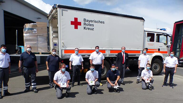 Die unterfränkische BRK-Führungsmanschaft und ein Teil der freiwilligen Helfer versammelte sich vor dem Lkw des Katastrophenschutzes Unterfranken.