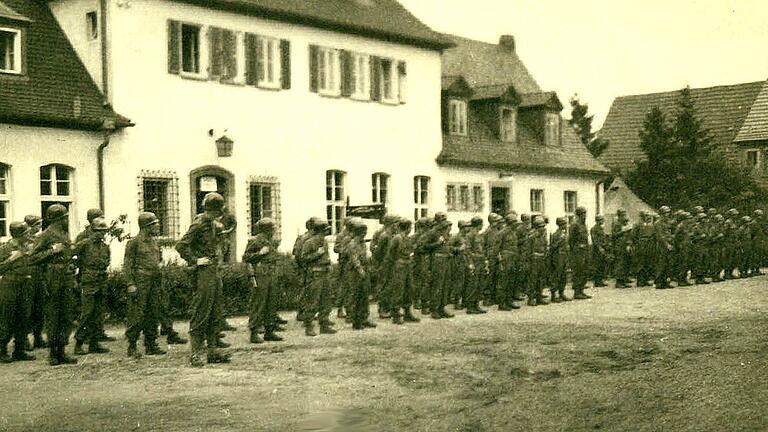 Ein Bild aus dem Jahr 1945: In voller Mannschaftsstärke ist die 99. Aufklärungseinheit der 99. US-Infanterie-Division vor der beschlagnahmten Berufsschule angetreten. Dort, in der Dreimühlenstraße, wo heute die Julius-Kardinal-Döpfner-Schule steht, hatte sie nach Kriegsende ihr Hauptquartier eingerichtet. Trotz sorgfältiger Recherche konnte der Rechteinhaber des Bildes nicht ermittelt werden. Rechteinhaber werden gebeten, sich bei der Redaktion zu melden.