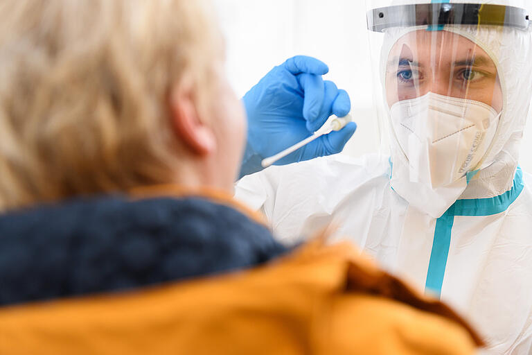 Ein Mitarbeiter in Schutzkleidung demonstriert im Corona Testzentrum an der Talavera in Würzburg die Vorgehensweise bei einem Corona-Test. Ein Mitarbeiter in Schutzkleidung demonstriert im Corona Testzentrum an der Talavera in Würzburg die Vorgehensweise bei einem Corona-Test.