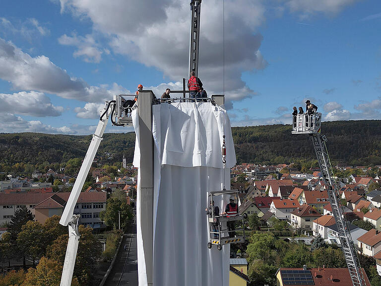 Mit Hilfe von professionellen Höhenarbeitern, Industriekletterern und der Feuerwehr konnte das Seminar den über 30 Meter hohen Glockenturm verpacken. Die Schülerinnen und Schüler durften auch nach oben fahren, um dort das Kreuz zu verhüllen. Mit Hilfe von professionellen Höhenarbeitern, Industriekletterern und der Feuerwehr konnte das Seminar den über 30 Meter hohen Glockenturm verpacken. Die Schülerinnen und Schüler durften auch nach oben fahren, um dort das Kreuz zu verhüllen. 