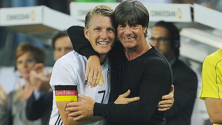 Fussball       -  Bastian Schweinsteiger (links) nach seiner Auswechslung in seinem letzten Länderspiel mit Bundestrainer Joachim Löw