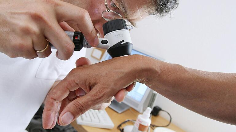 Ein Dermatologe untersucht die Haut einer Frau. Unter anderem mit Hautärzten gilt Rhön-Grabfeld als überversorgt, Termine sind dennoch schwer zu bekommen. Das frustriert Patientinnen und Patienten. Ein Dermatologe untersucht die Haut einer Frau. Unter anderem mit Hautärzten gilt Rhön-Grabfeld als überversorgt, Termine sind dennoch schwer zu bekommen. Das frustriert Patientinnen und Patienten.