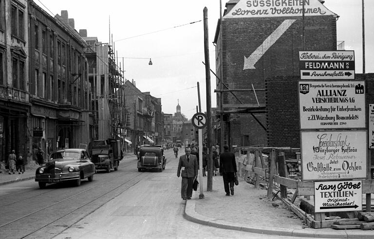 Die Kaiserstraße im Wiederaufbau im Jahr 1948. Der Pfeil auf der Fassade macht auf das Lebensmittel- und Süßigkeitengeschäft 'Lorenz Vollkommer' aufmerksam.