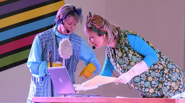 Die beiden Putzfrauen Hilde (Sabine Eckert/links) und Lisbeth (Christine Kasamas) kommen aus dem Staunen nicht raus, ob all der Neuigkeiten, auf die sie beim Saubermachen und versehentlichen Tastendrücken am Computer im Urspringer Rathaus stoßen. Die beiden Putzfrauen Hilde (Sabine Eckert/links) und Lisbeth (Christine Kasamas) kommen aus dem Staunen nicht raus, ob all der Neuigkeiten, auf die sie beim Saubermachen und versehentlichen Tastendrücken am Computer im Urspringer Rathaus stoßen.