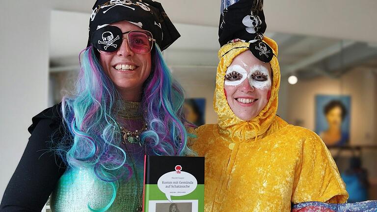 Mee-Jungfrau Gemünda (Mareen Kasper) und Mee-Fischle Gemo (Alexandra Reichel) mit dem zweiten Buch von Kasper über die Mee-Jungfrau und ihre Abenteuer.