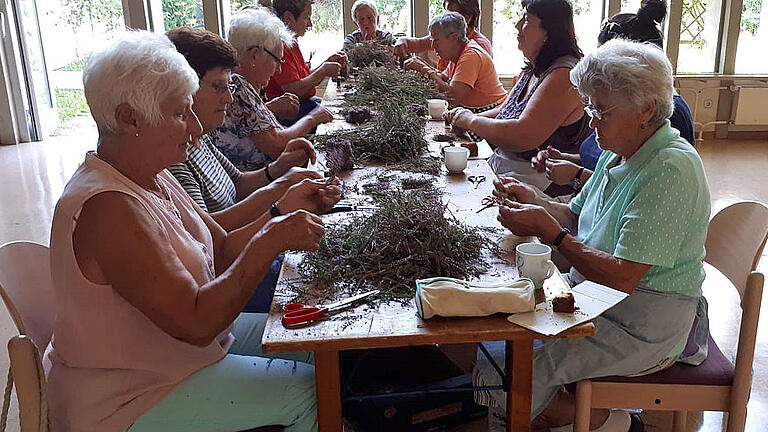 So wie hier in Rimpar binden insgesamt etwa 50 fleißige Frauen in Teilheim und Pleichfeld bis zu 800 der kleinen Heidekränzchen für die Pilgerkreuze und als Mitgbringsel. Wegen der ungewöhnlich heißen Temperaturen wurden die Kränzchen zur besseren Haltbarkeit schockgefrostet. Foto: Günther Wagenbrenner So wie hier in Rimpar binden insgesamt etwa 50 fleißige Frauen in Teilheim und Pleichfeld bis zu 800 der kleinen Heidekränzchen für die Pilgerkreuze und als Mitgbringsel. Wegen der ungewöhnlich heißen Temperaturen wurden die Kränzchen zur besseren Haltbarkeit schockgefrostet. Foto: Günther Wagenbrenner
