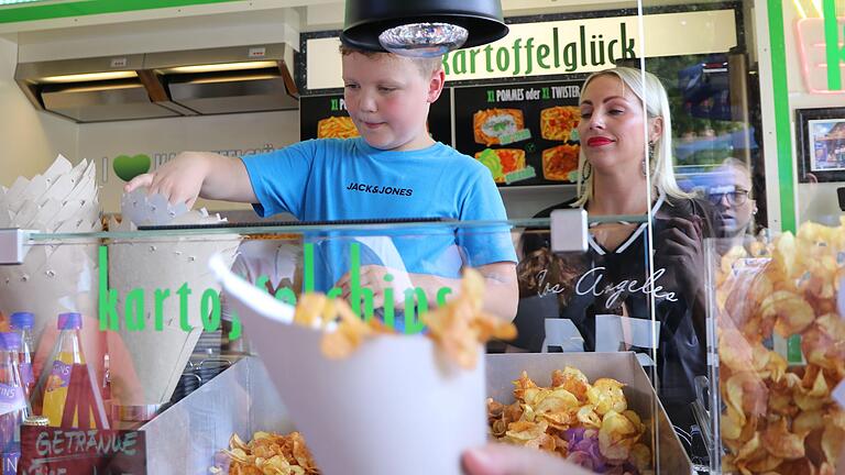 Laurenz (8 Jahre) aus Marienbrunn durfte während der Backstage-Tour auf der Marktheidenfelder Laurenzi-Messe am Stand 'Kartoffelglück' von Charlyn Klimkeit-Agtsch Kartoffelchips herstellen und an die anderen Teilnehmenden ausgeben. Laurenz (8 Jahre) aus Marienbrunn durfte während der Backstage-Tour auf der Marktheidenfelder Laurenzi-Messe am Stand 'Kartoffelglück' von Charlyn Klimkeit-Agtsch Kartoffelchips herstellen und an die anderen Teilnehmenden ausgeben.